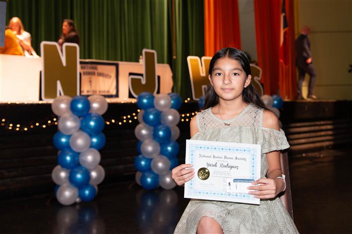 A new member posing with her certificate